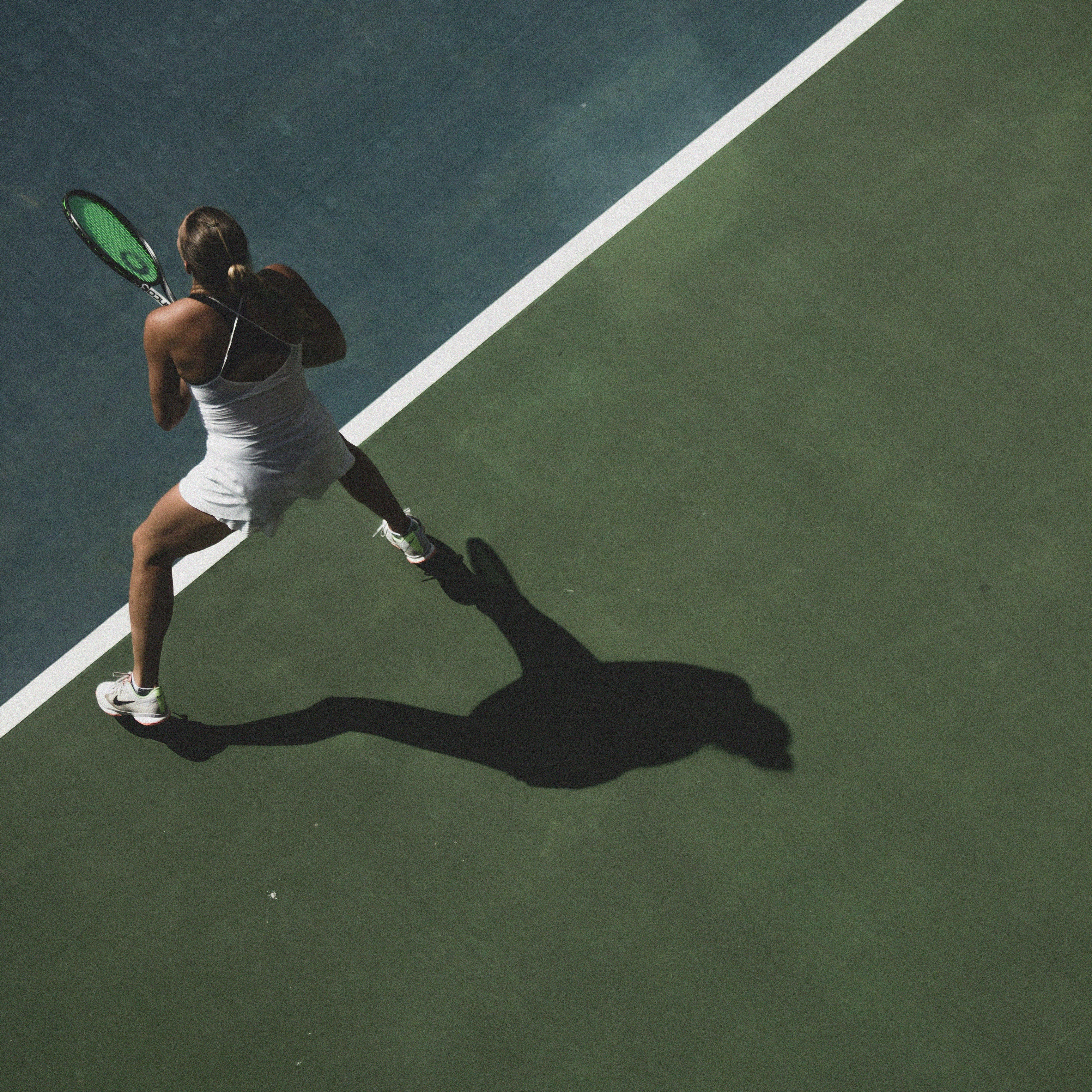 Tennisspielerin bereit zum Schlag auf grünem Tennisplatz