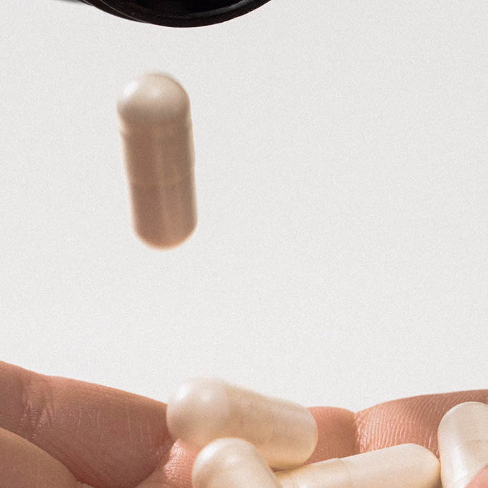 Kapseln fallen von einer Dose in die Hand einer Frau